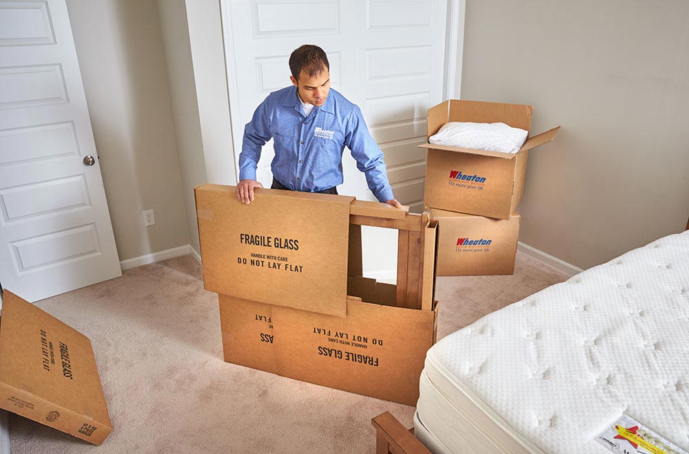 A worker from Wheaton Worldwide Moving packing up a mirror