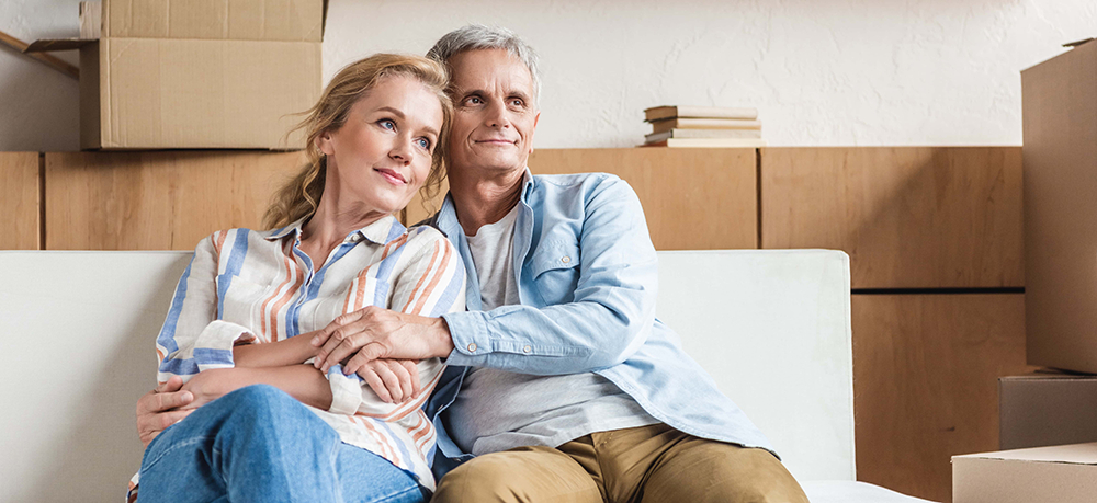 A couple sitting on the couch in their new home