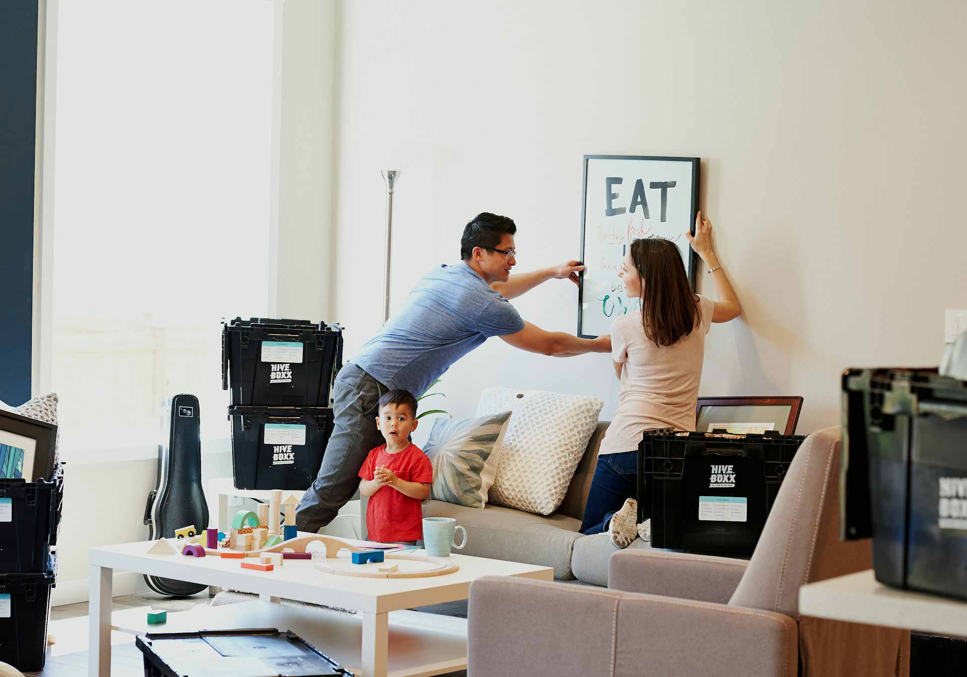 Couple with young child unpacking boxes after a move